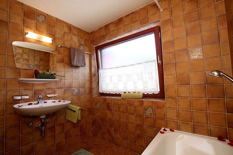 Badezimmer mit Wanne in der Ferienwohnung Alpkopf im Ausfernerhof in Berwang